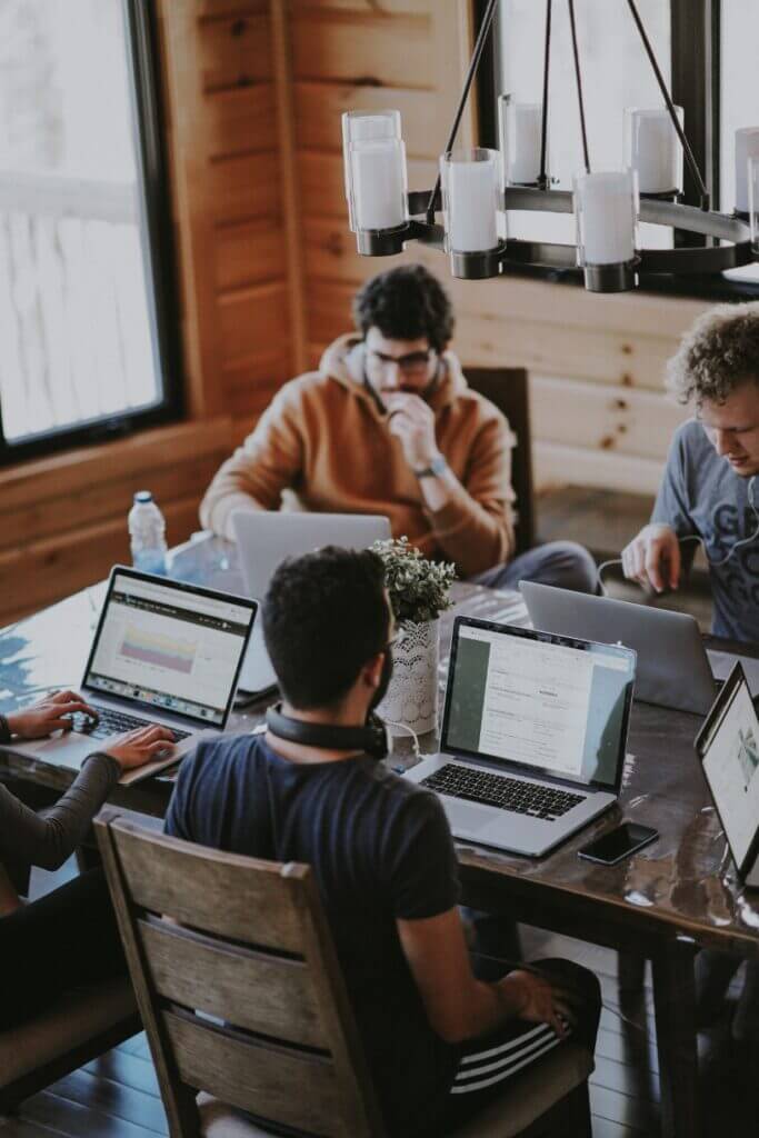 People sitting around table working on laptops