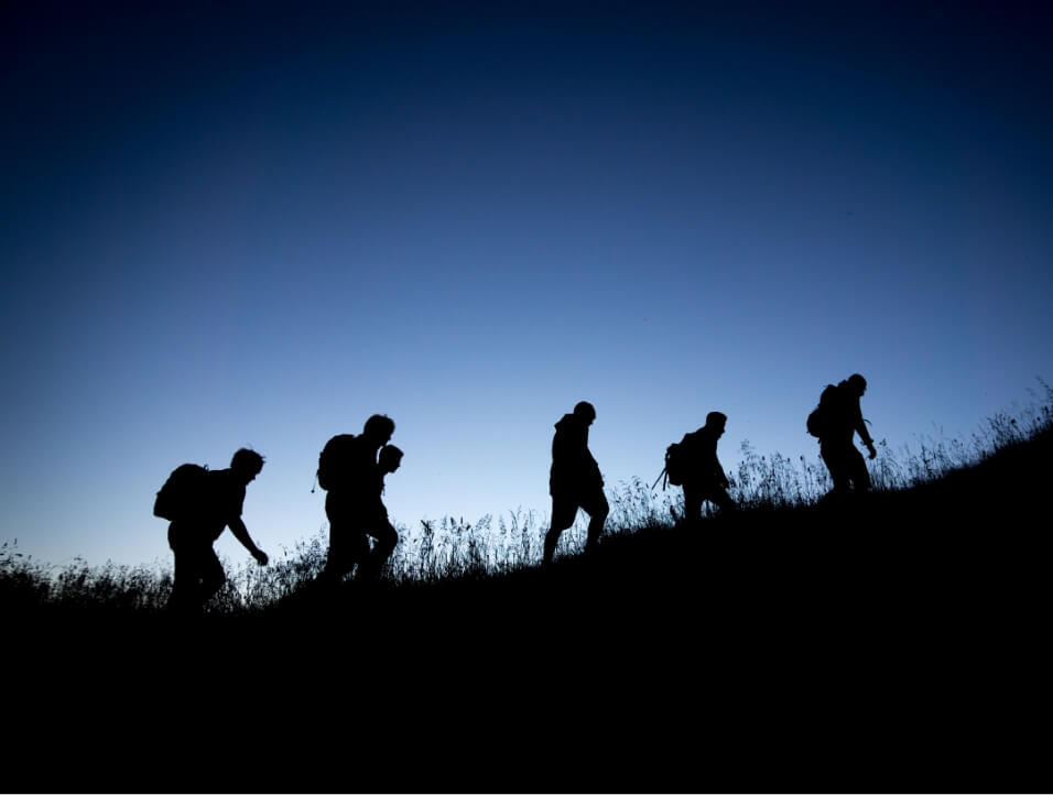 People hiking at dawn or dusk
